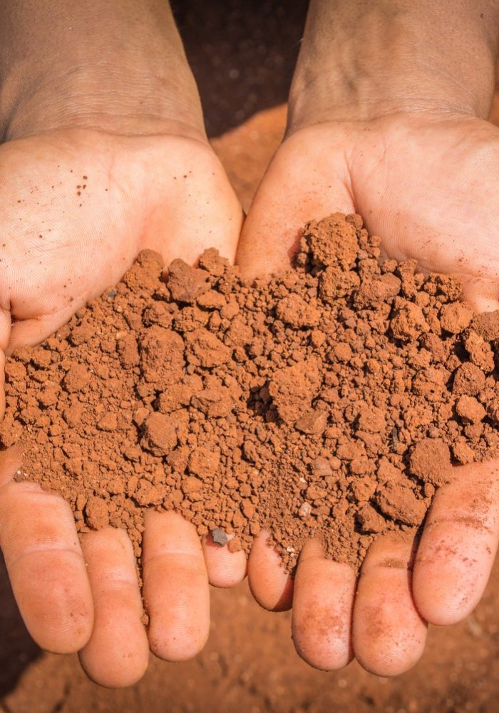 Red,Dry,Soil,On,Hands,In,The,Drought,Land.